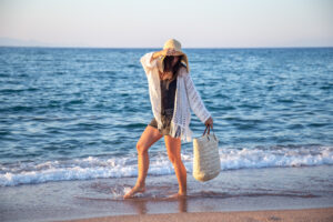 Mulher na praia com bolsa